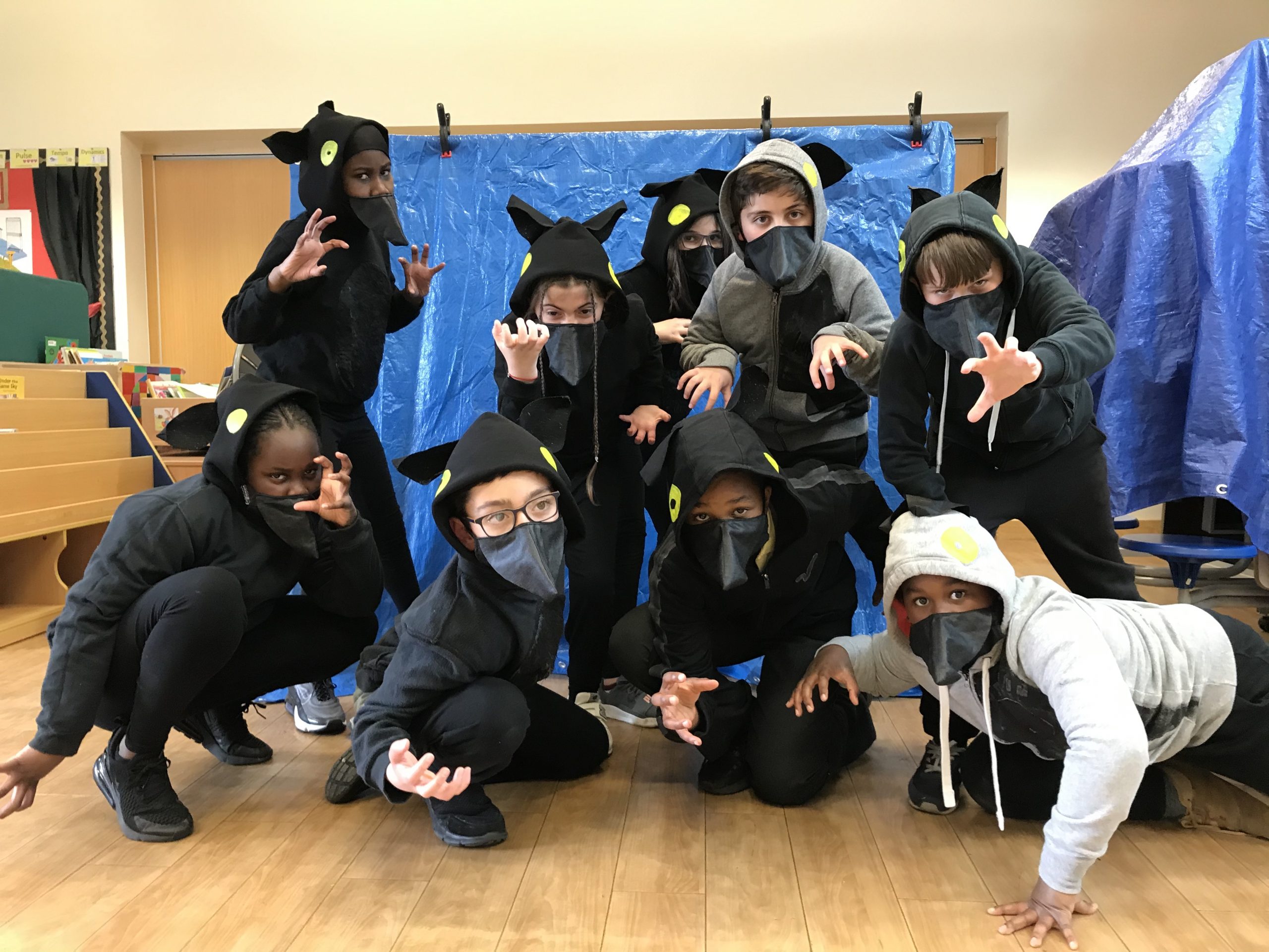 Group of school children in their wolf costumes with pointy ears and masks.