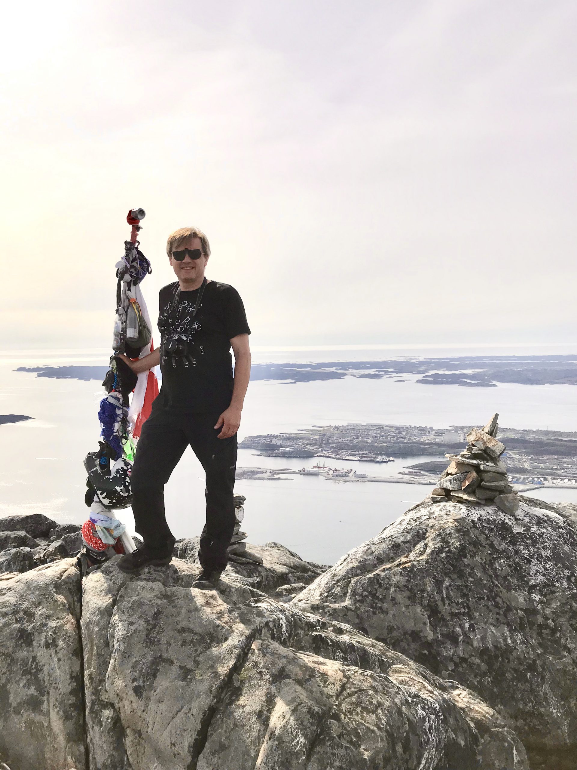 Image of Søren standing on mountain top holding pole
